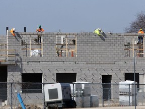 Construction workers and masons were busy preparing roadways and laying concrete block on portions of Farhi Holdings' Rosewater Estates, a commercial/residential development located on Lauzon Road at McHugh Street Wednesday, March 17, 2021.