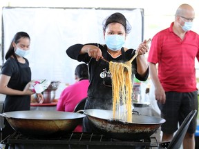 Leny Inting of Tropical Hut prepares noodles and chicken during WindsorEats Food Hall event at Lanspeary Park Lions on Sept. 4, 2021, during the COVID-19 lockdown. The outdoor venue saw food vendors sell their wares to guests dining at picnic tables spaced apart from each other.