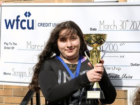 WFCU Credit Union Scripps Regional Spelling Bee champion Mareela Eshaq, centre, holds the championship trophy following a brief ceremony with her family and Beth Ann Prince of Windsor Family Credit Union presenting a $200 cheque and medal and offering her congratulations.