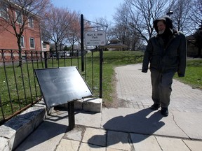 A passerby glances at an empty plaque support at Mary E. Bibb Park, Wednesday March 31, 2021.