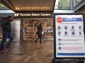 People arrive at the entrance to the Toronto Eaton Centre in downtown Toronto, on Nov. 23, 2020, the first day of a new lockdown in the city.