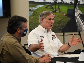 In this file photo taken on August 29, 2020, Texas Governor Greg Abbott (right), with Senator Ted Cruz, attends a briefing in Orange, Texas.