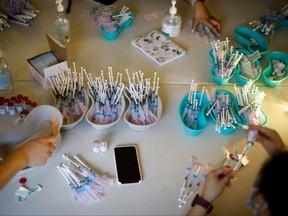 Health-care workers from Humber River Hospital draw out doses of the Moderna COVID-19 vaccine before administering the vaccine to residents at a LOFT community housing complex in Toronto, March 26, 2021.