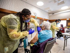 Nurse Tahani McDonald from Humber River Hospital administers the Moderna COVID-19 vaccine at a Toronto Community Housing seniors building in the northwest end of Toronto, March 25, 2021.