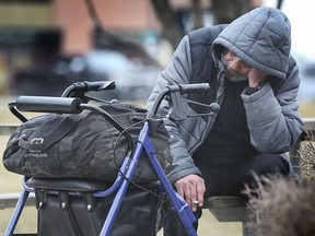 A man who has been staying at the Windsor International Aquatic Centre has a cigarette outside of the temporary shelter on Wednesday, March 10, 2021.