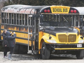 A couple of women check out burned out buses at a compound at 12 Seacliff Drive East in Leamington on Thursday. OPP say the fire was intentionally set and a total of six buses were damaged.