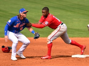 Washington Nationals outfielder Victor Robles holds on to New York Mets infielder Jeff McNeil to try and stay on the bag after stealing second base in the fifth inning of a spring training game at Clover Park.