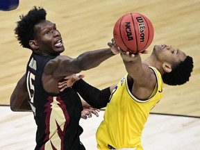 Florida State Seminoles center Quincy Ballard (left) fouls Michigan Wolverines guard Zeb Jackson in the second half during the Sweet 16 of the 2021 NCAA Tournament at Bankers Life Fieldhouse.
