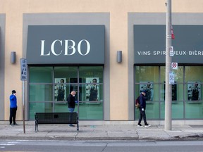 People wait outside of the LCBO in Toronto on April 9, 2020.