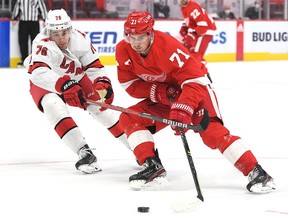 Detroit Red Wings center Dylan Larkin skates the puck up ice against Carolina Hurricanes defenseman Brady Skjei during the second period at Little Caesars Arena.