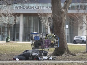 A man sleeps in a park near City Hall Square on Thursday, March 11, 2021.
