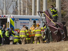 Emergency crews work to free a person trapped in their vehicle after it rolled into a hydro pole on Ojibway Parkway in front of the Lou Romano Water Plant on Tuesday, March 23, 2021.
