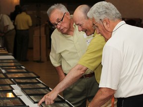 WINDSOR, ONT.: JUNE 9, 2012 -- Patterson alumni, from left, John Newton, Gary Wortley, and Ted Collins, look over photos of old Patterson sports teams while at the Patterson Collegiate Institute's 124th reunion in the Masonic Temple Ballroom, Saturday, June 9, 2012.