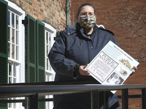 Heather Colautti, registrar with Museum Windsor poses on Tuesday, March 2, 2021 with a collage of photos and newspaper clippings from 1918 when the city was dealing with the Spanish Flu.