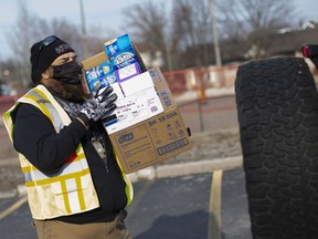 John Levesque from Local 195, grabs a box of donated tampons during the Tampon Tuesday Drive-Thru Drop Off Event outside the offices of United Way/Centraide Windsor-Essex County on Tuesday, March 9, 2021.