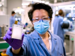 FILE PHOTO: A GM employee poses with an example of the company's next-generation lithium metal batteries at  GM Chemical and Materials Systems Lab in Warren, Michigan, U.S. September 9, 2020. Picture taken September 9, 2020.