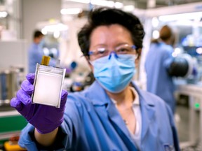 A GM employee poses with an example of the company's next-generation lithium metal batteries at  GM Chemical and Materials Systems Lab in Warren, Michigan, U.S. September 9, 2020.