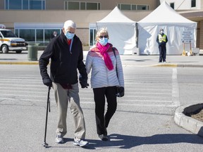 Dr. John Anderson is accompanied by his wife, Jean Anderson, as they leave the WFCU Centre after he received his COVID-19 vaccine on Tuesday, March 2, 2021.