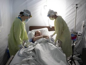 COVID-19 patient Vince Norris, 65, is looked after by medical staff at Windsor Regional Hospital's field hospital at the St. Clair College SportsPlex on May 13, 2020, during the COVID-19 pandemic.