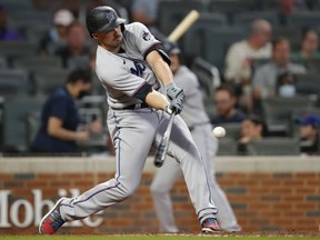 Adam Duvall of the Miami Marlins hits a two-run double in the fourth inning of an MLB game against the Atlanta Braves at Truist Park on April 13, 2021 in Atlanta, Georgia.