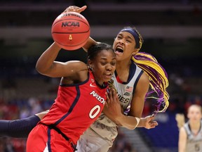 Aaliyah Edwards of the UConn Huskies reaches over Trinity Baptiste #0 of the Arizona Wildcats during the third quarter in the Final Four semifinal game of the 2021 NCAA Women's Basketball Tournament at the Alamodome on April 02, 2021 in San Antonio, Texas.