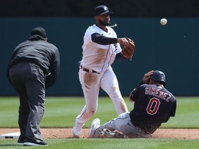 Willi Castro of the Detroit Tigers turns a double play over Andres Gimenez of the Cleveland Indians during the third inning at Comerica Park on April 03, 2021 in Detroit, Michigan.
