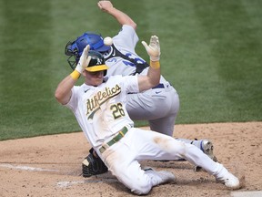 Matt Chapman of the Oakland Athletics scores the tying run head of the throw to catcher Will Smith of the Los Angeles Dodgers in the ninth inning at RingCentral Coliseum on April 07, 2021 in Oakland, California.