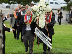 Members of the Armenian diaspora in the U.S. carry an arrangement of flowers as they gather in remembrance of the 1915 genocide, which was acknowledged by U.S. President Joe Biden, at the Armenian Martyrs Monument in Montebello, Calif., April 24, 2021.
