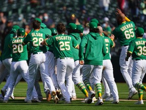 Athletics players celebrate after a walk off victory in the 10th inning against the Twins at RingCentral Coliseum in Oakland, Calif., April 21, 2021.