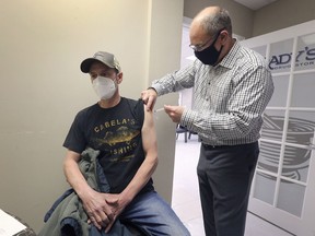 BELLE RIVER, Chris Laramie, 56, receives a dose of the AstraZeneca vaccine on Tuesday, April 20, 2021 from pharmacist Tim Brady at the Brady's Drug Store in Belle River.