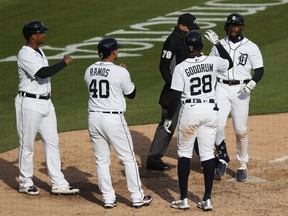 Detroit Tigers' rookie outfielder Akil Baddoo (60) touches home plate and celebrates with Niko Goodrum (28) Wilson Ramos (40) and Jonathan Schoop (7) after hitting a grand slam home run in the ninth inning of Monday's loss to the Minnesota Twins.