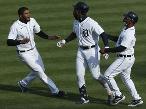 Detroit Tigers center fielder Akil Baddoo (60) celebrates with third baseman Jeimer Candelario (left) and first base coach Ramon Santiago (right) after hitting a walk off single to win the game in the tenth inning against the Minnesota Twins at Comerica Park. Mandatory Credit: Raj Mehta-USA TODAY Sports