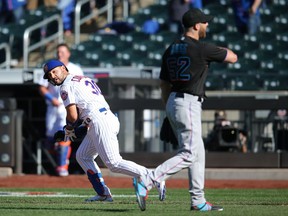 New York Mets right fielder Michael Conforto runs to first base after being hit by a pitch by Miami Marlins relief pitcher Anthony Bass to force in the winning run during the ninth inning of an opening day game at Citi Field.
