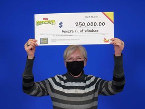 Anezka "Angie" Clark, 65, of Windsor, holds up her $250,000 prize cheque from playing Instant Crossword Deluxe.