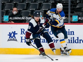 Colorado Avalanche defenseman Samuel Girard and St. Louis Blues left wing Kyle Clifford battle for the puck in the first period at Ball Arena.