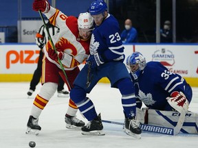 Calgary Flames forward Joakim Nordstrom and Toronto Maple Leafs defenseman Travis Dermott battle for the puck in front of goaltender David Rittich during the second period at Scotiabank Arena.