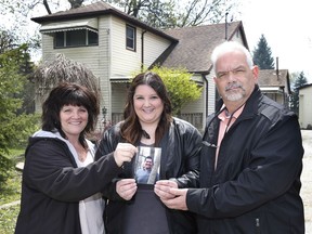 Christine Gaudet (left), Rachelle (center), and Germain (right) hold a photo of the late Julien Gaudet outside the home they donated to Julien's House: A registered charity that offers free bereavement services. Photographed April 23, 2021.