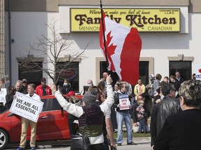 A group of demonstrators are shown in front of the Family Kitchen restaurant in Leamington, Ontario on Tuesday, April 6, 2021. The restaurant defied provincial orders and opened for business. The group held a demonstration to support the business owner and protest against lockdown orders.