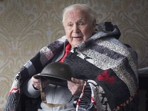 Second World War veteran Ken Douglas, 97, poses on Thursday, April 8, 2021, with the helmet he was issued in 1942 and the Quilts of Valour Canada quilt he received. Douglas lives at the Chartwell St. Clair Beach Retirement Residence.