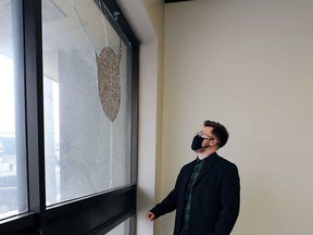 Alexander Reid, executive director of Trans Wellness Ontario (formerly W.E. Trans Support), looks at the damage caused by targeted vandalism at the organization's offices on Tecumseh Road East. Photographed Feb. 22, 2021.