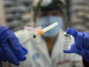 Jasjit Garcha, pharmacist and associate/owner at Shoppers Drug Mart on Huron Church Road, prepares an AstraZeneca COVID-19 vaccine shot on Friday, April 9, 2021.