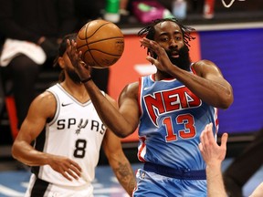 James Harden of the Brooklyn Nets heads for the net as Patty Mills of the San Antonio Spurs defends in the third quarter at Barclays Center on May 12, 2021 in the Brooklyn borough of New York City.