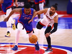 Josh Jackson of the Detroit Pistons battles for a loose ball against Gabe Vincent of the Miami Heat in the second half at Little Caesars Arena on May 16, 2021 in Detroit, Michigan.