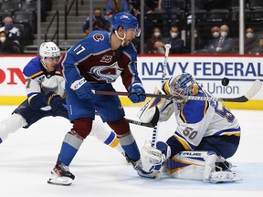 Jordan Binnington of the St. Louis Blues blocks a shot by Tyson Jost of the Colorado Avalanche as Niko Mikkola defends during Game One at Ball Arena on May 17, 2021 in Denver.