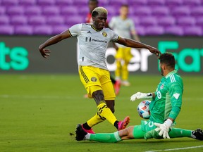 Toronto FC goalkeeper Alex Bono blocks a shot by Columbus' Gyasi Zerdes during the first half in Orlando on Wednesday, May 12, 2021.