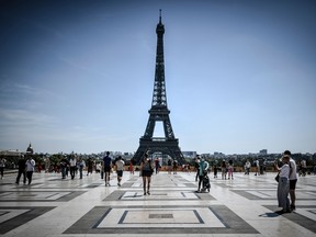 Tourists visit the Esplanade des Droits de l'Homme with the Eiffel Tower in the background, in Paris on August 6, 2020.