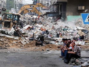 An excavator clears the rubble of a destroyed building in Gaza City's Rimal residential district on May 16, 2021, following massive Israeli bombardment on the Hamas-controlled enclave.