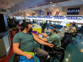 A healthcare worker administers the Pfizer/BioNTech vaccine at Woodbine Racetrack pop-up vaccine clinic in Toronto May 5, 2021.