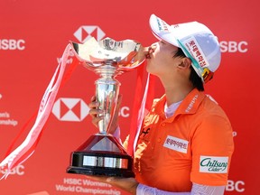 South Korea's Kim Hyo-joo poses with the winner's trophy after winning the HSBC Women's World Championship at Sentosa Golf Club in Singapore on May 2, 2021.