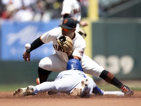 San Francisco Giants second baseman Donovan Solano takes the throw in time to tag out Los Angeles Dodgers shortstop Gavin Lux as he attempts to steal second base during the first inning at Oracle Park.